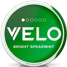 Green circular VELO Bright Spearmint tin with white text, a white rim, and strength indicator dots.